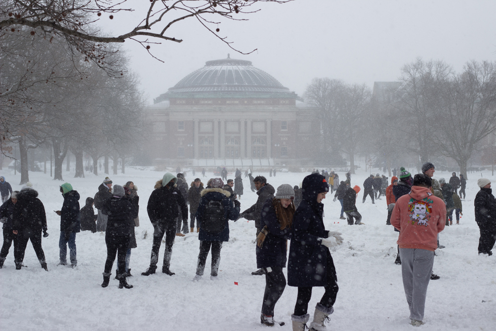 A snowball fight on the U of I quad. A large crowd of students in winter gear are throwing snowballs. Photo by Jorge Murga. 
