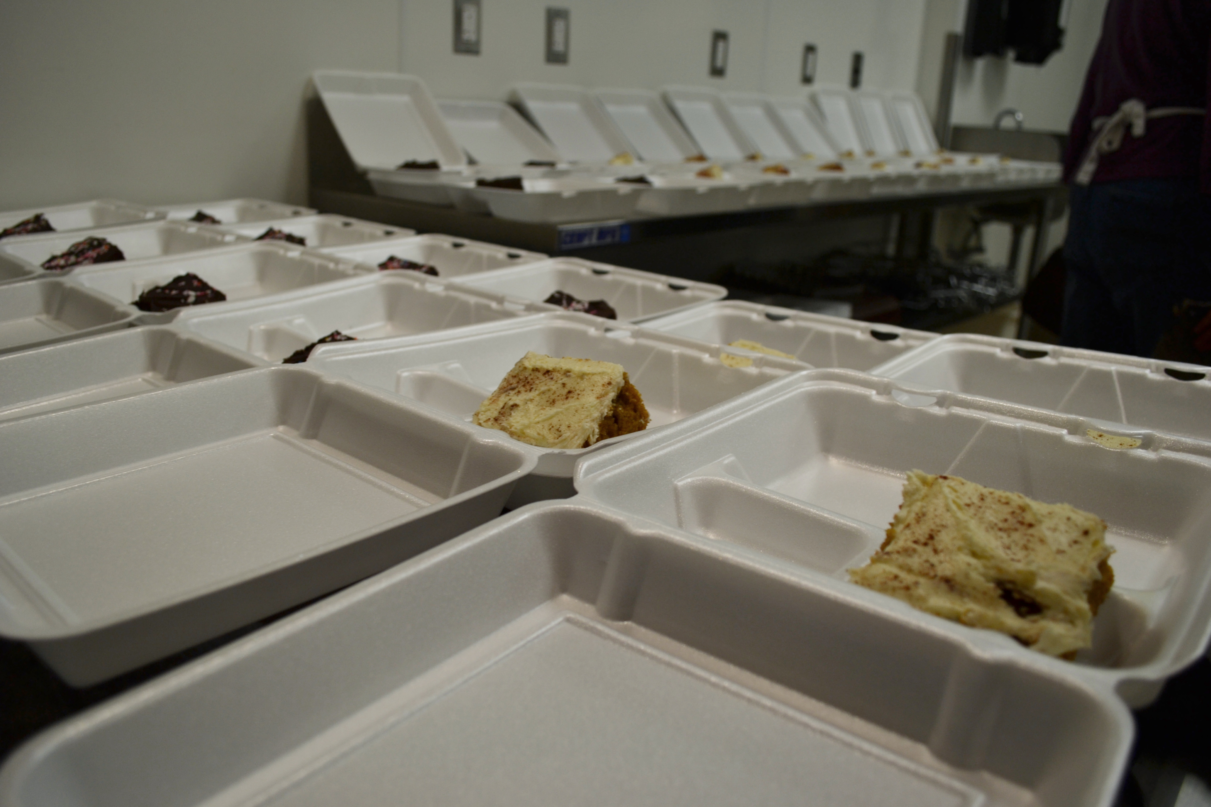 Many clamshell containers have one slice of cake and other partitions ready for scooping food. Photo by Alyssa Buckley.