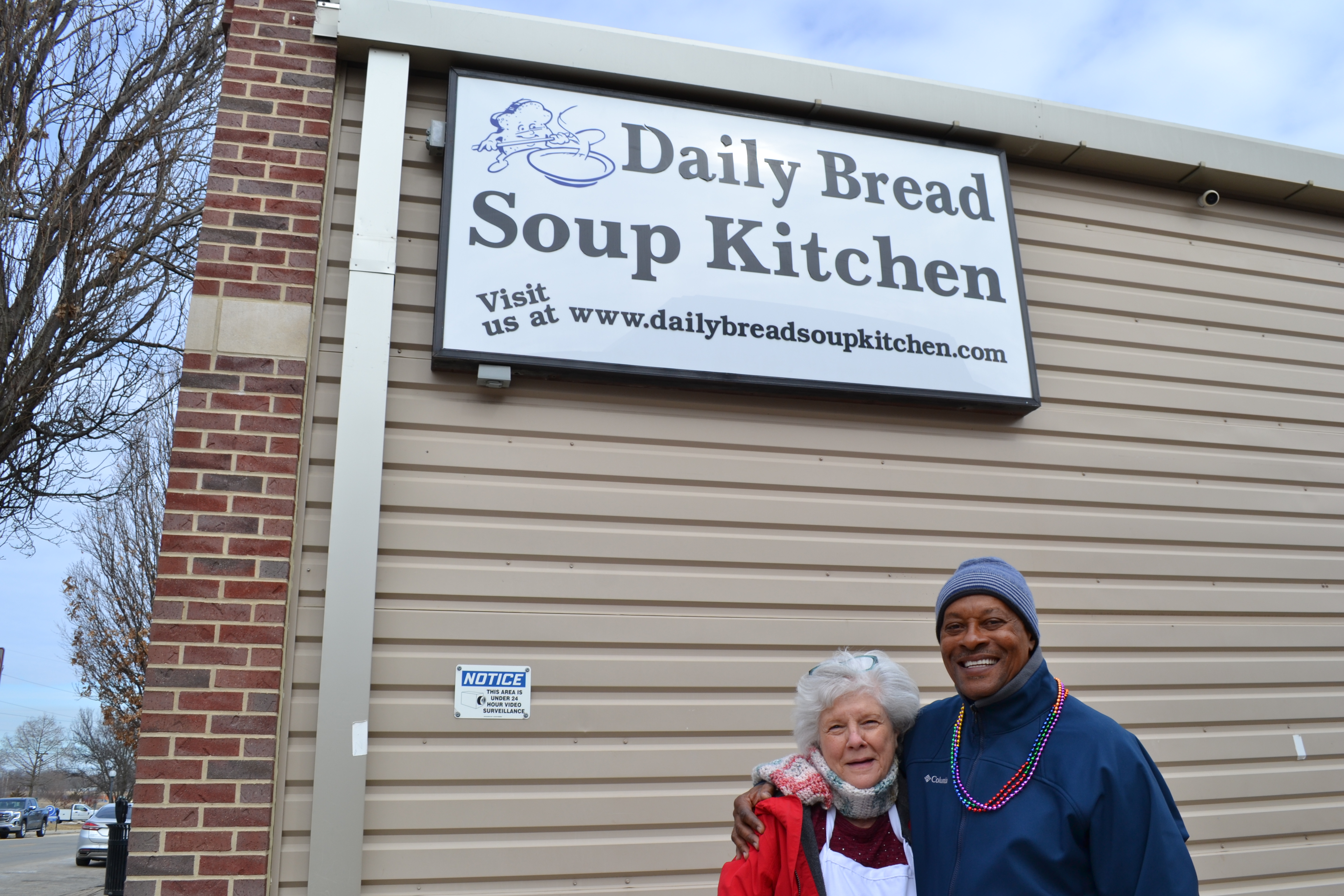 Two volunteers Ruth Ann Evans and Charlie Brown smile for the camera outside of the Daily Bread Soup Kitchen. Photo by Alyssa Buckley.