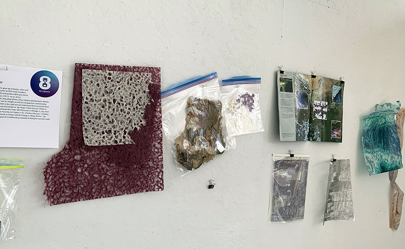 Artist Sarah Marjanovic's collage supplies hanging on the wall of her work area at 8 to Create.