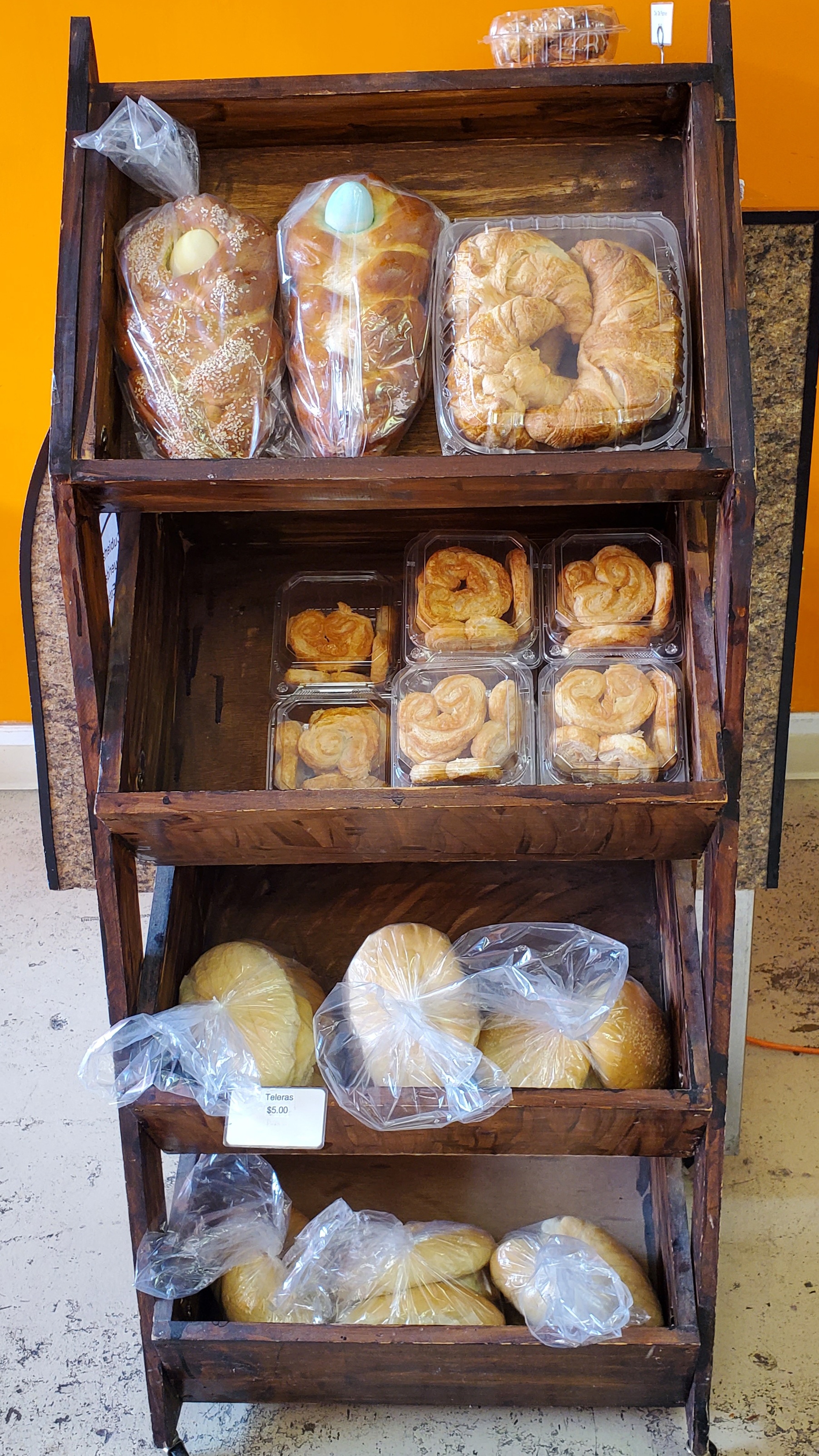 In a wooden case, there are breads wrapped in plastic bags for sale inside Rick's Bakery. Photo by Carl Busch.