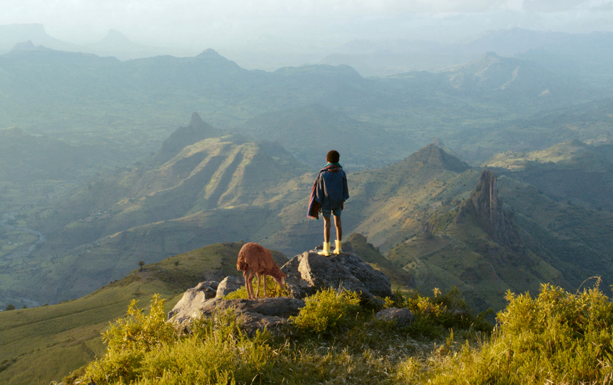 On the mountains in Ethiopia, there is a Black boy and his lamb. Photo by Kimstim Films.