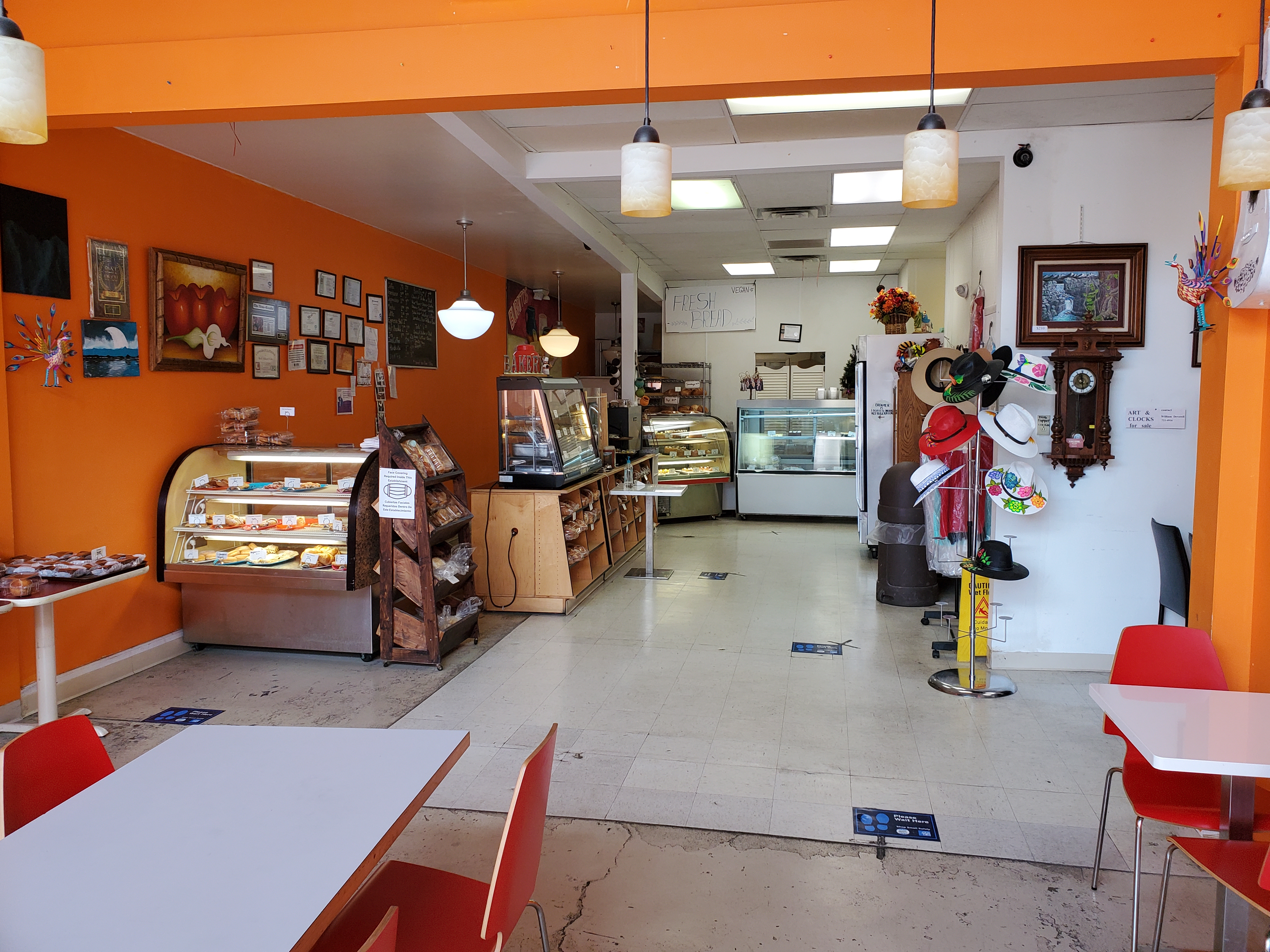 Inside Rick's Bakery, there are several cases of baked goods to the left. The walls are painted a saturated orange. Photo by Carl Busch.