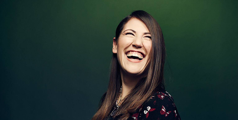 Color portrait of playwright, director, actor Madeline Sayet laughing. 