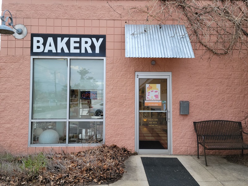 The entrance of The Cake Artistâ€™s Studio with a pull handle door and a welcome mat outside. Photo by Matthew Macomber.