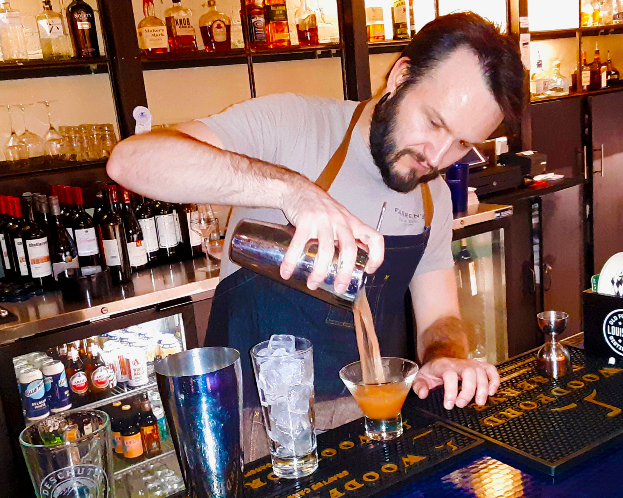Terry Boyer, bartender at Farren's Pub in Champaign, pours a cocktail into a half glass. Photo by Paul Young.