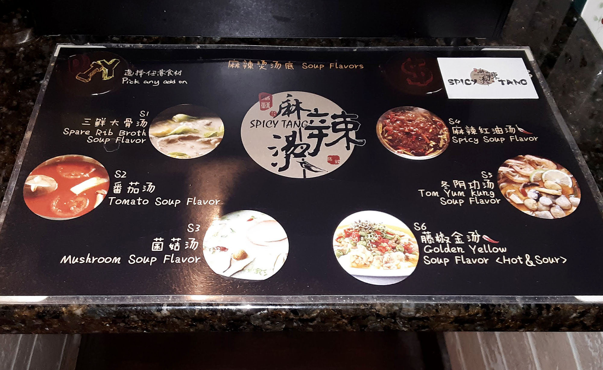 A laminated chart shows six broth choices at Spicy Tang. Photo by Paul Young.