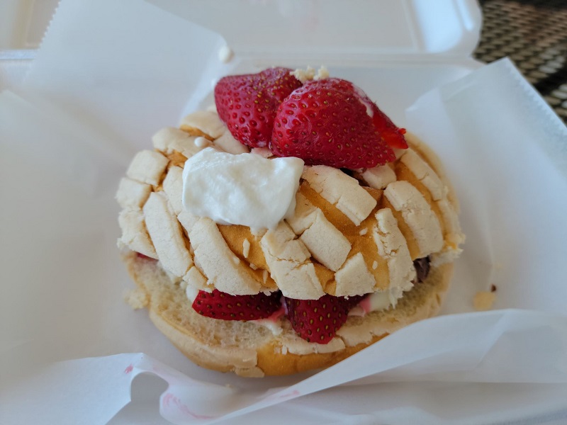 A concha con Nutella sandwich on an outdoor table at El Oasis with strawberries and whipped cream on top. Photo by Matthew Macomber.