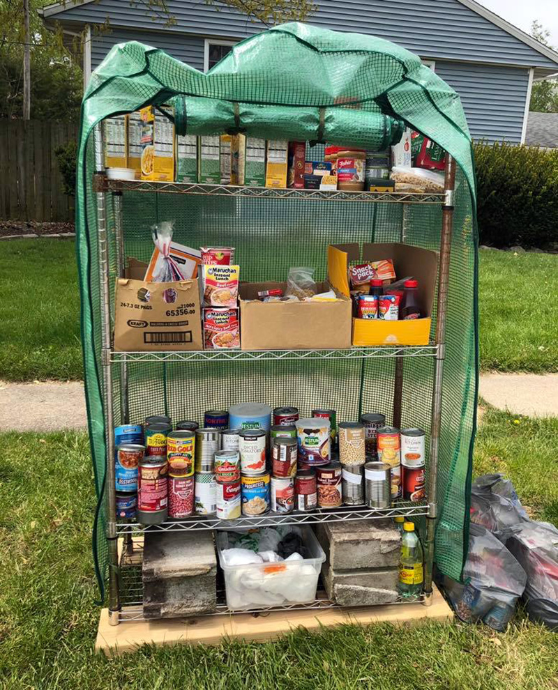 Photo of homemade food pantry set up on a front lawn. 