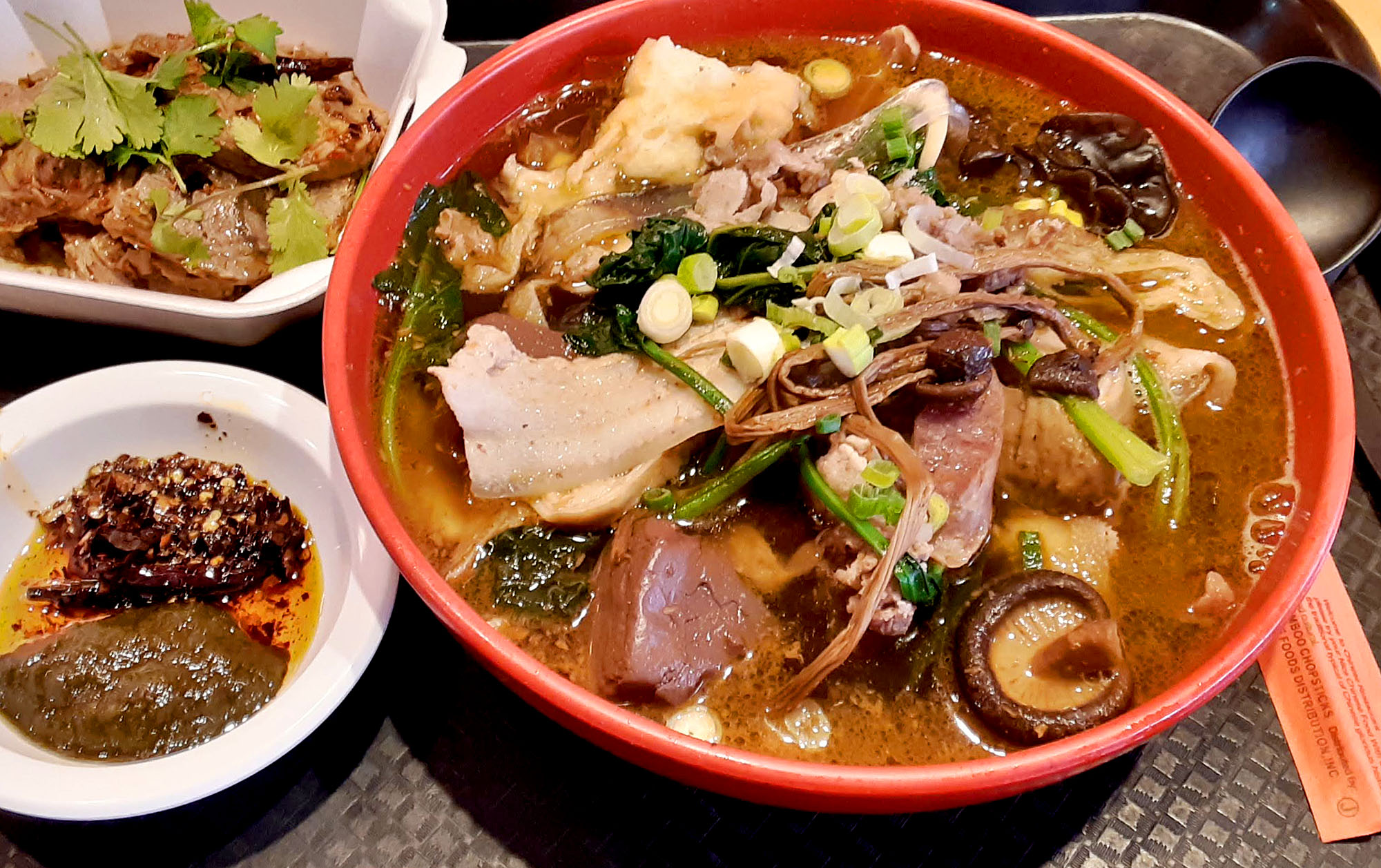 A huge bowl of meaty ramen with two small sides. Photo by Paul Young.