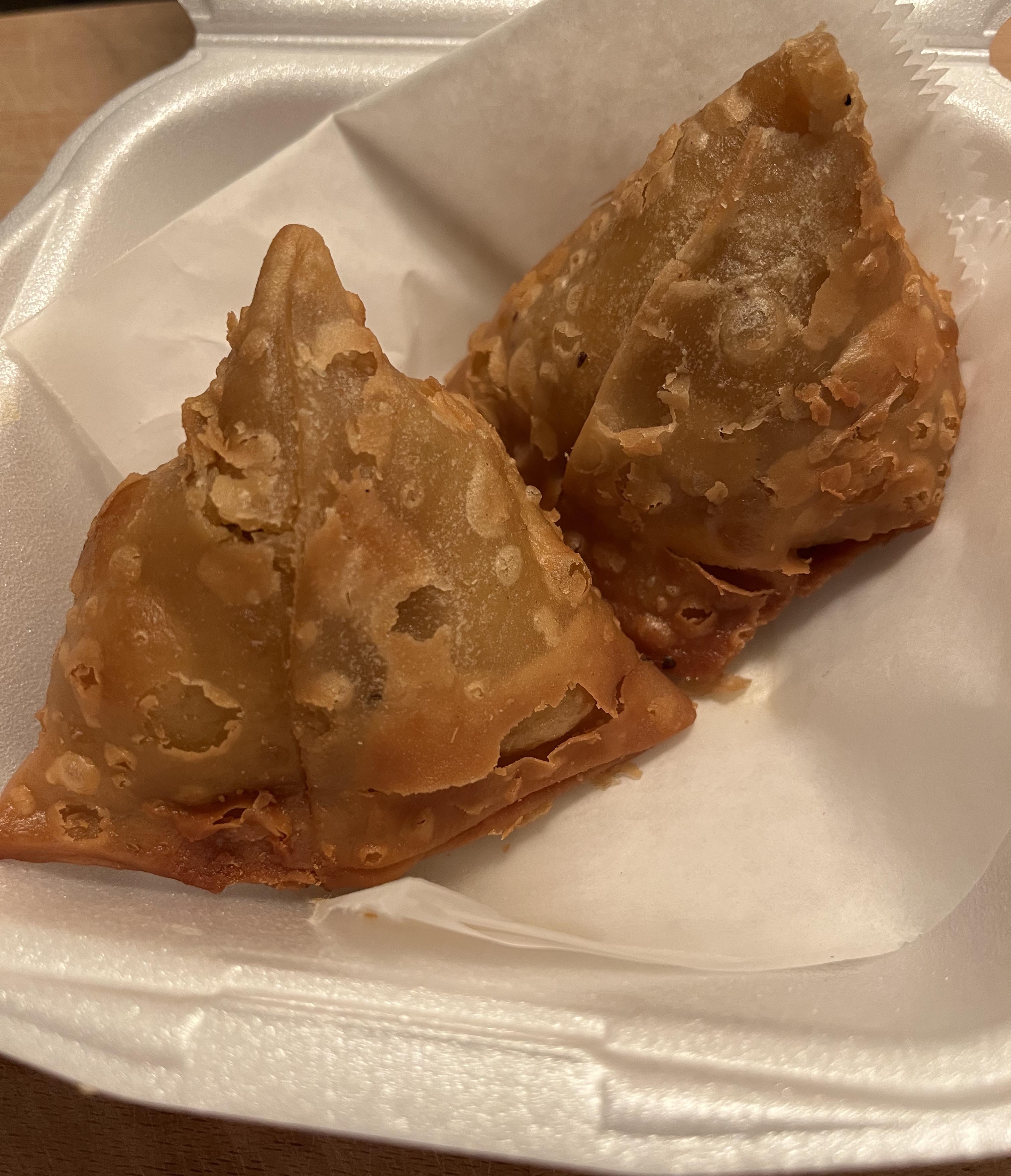 Two samosas in a styrofoam container from Stango Cuisine. Photo by Rafay Khan.