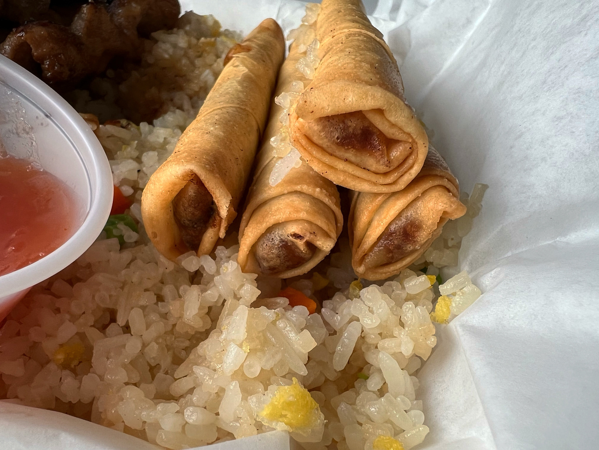 Four lumpia from Maria's Kitchen are stacked on top of fried rice. Photo by Alyssa Buckley.
