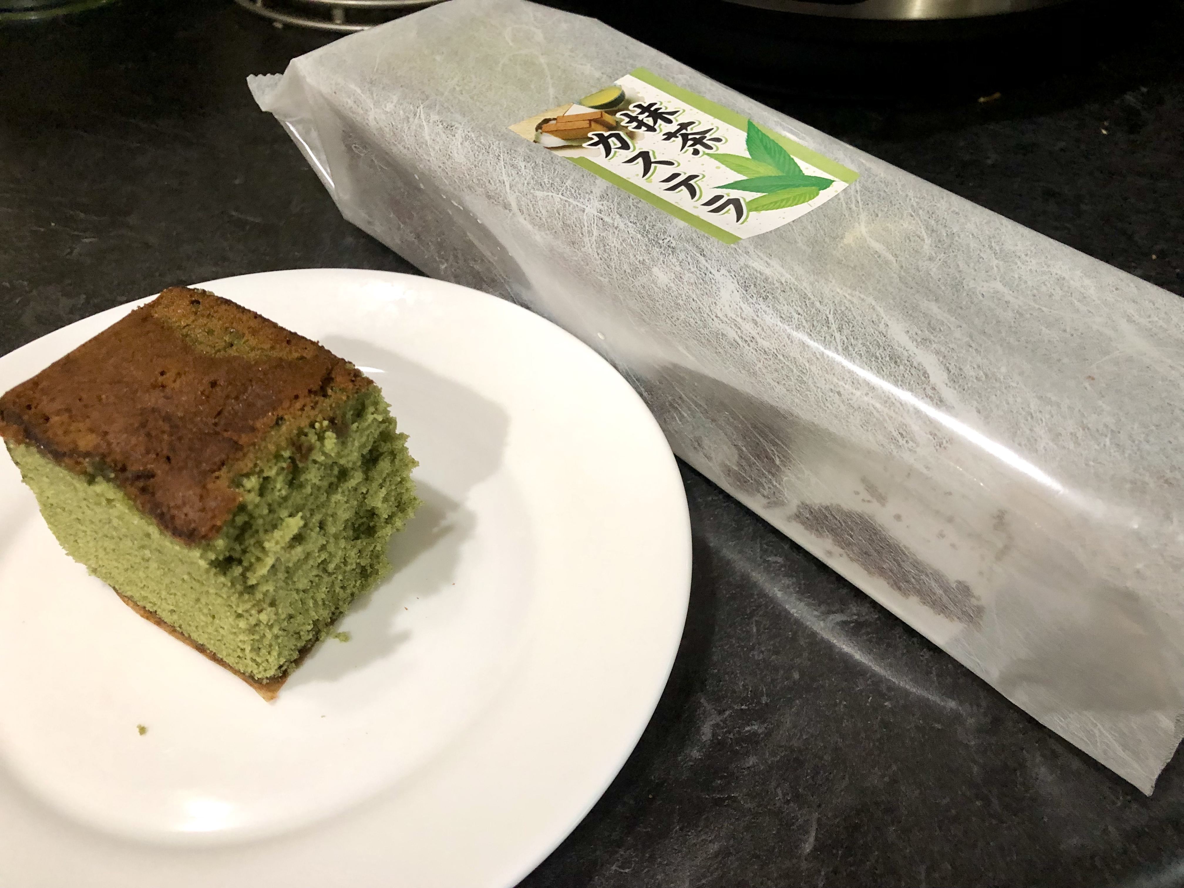 On a white plae, there is a slice of Karaku green tea cake. Photo by Xiaohui Zhang.