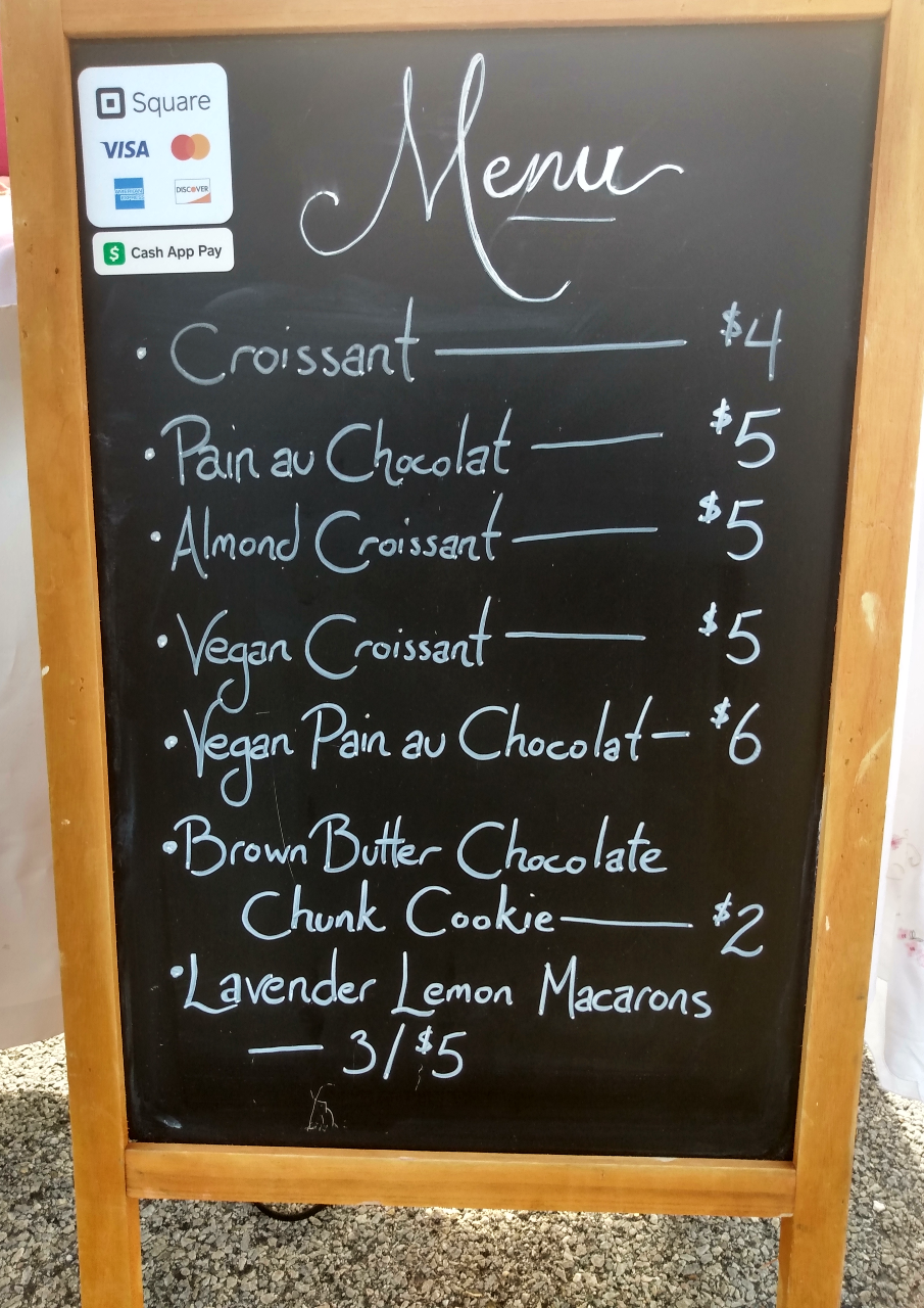 The chalkboard menu of Pastry Daydreams selections. It is housed in a wood frame in front of the display table. Photo by Michael O'Boyle.
