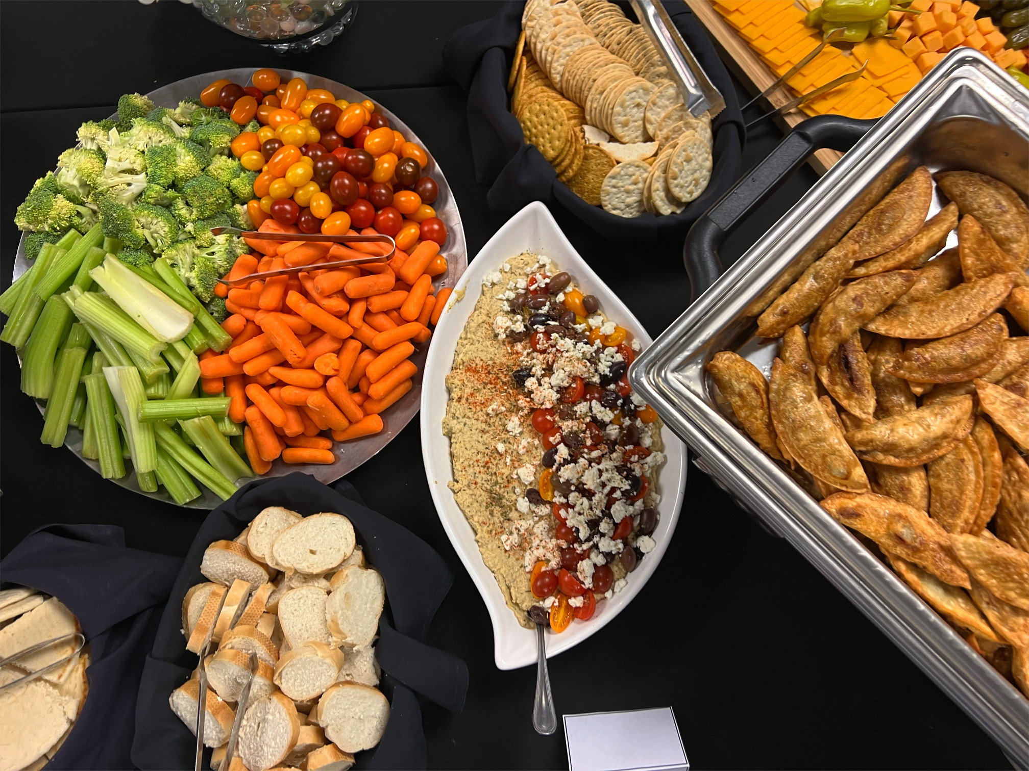 On a black table, trays of appetizers catered by Dish Passionate Cuisine are beautifully arranged. Photo by Alyssa Buckley.