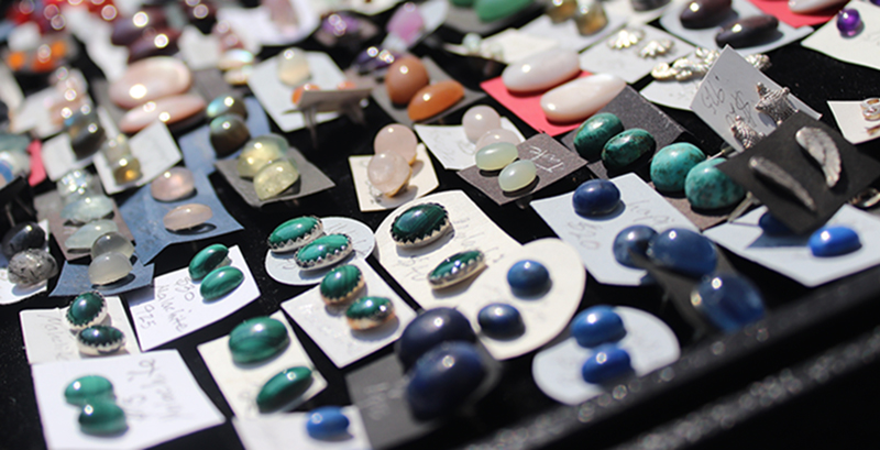 A table filled with gemstone earrings.