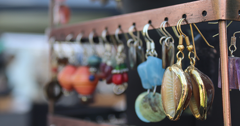 A photo of handmade gemstone earrings hanging on a rack.