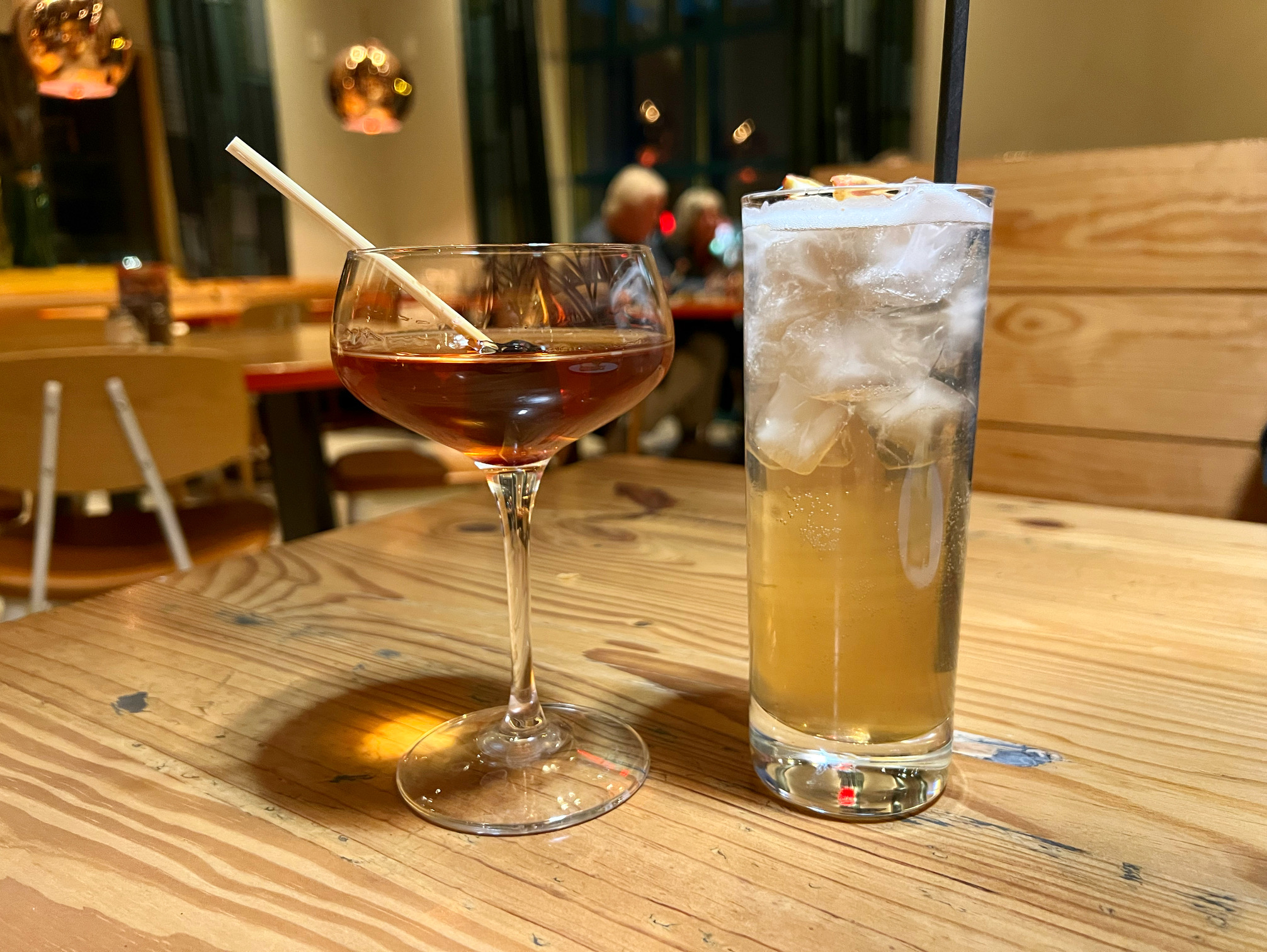 On a wooden table at Everyday Kitchen, there are two cocktails from the fall menu. Photo by Alyssa Buckley.