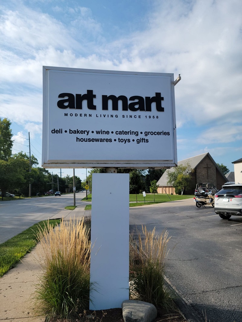 Art Martâ€™s outdoor sign reading â€œModern Living since 1958â€ and also â€œdeli, bakery, wine, catering, groceries, housewares, toys, giftsâ€. Photo by Matthew Macomber.