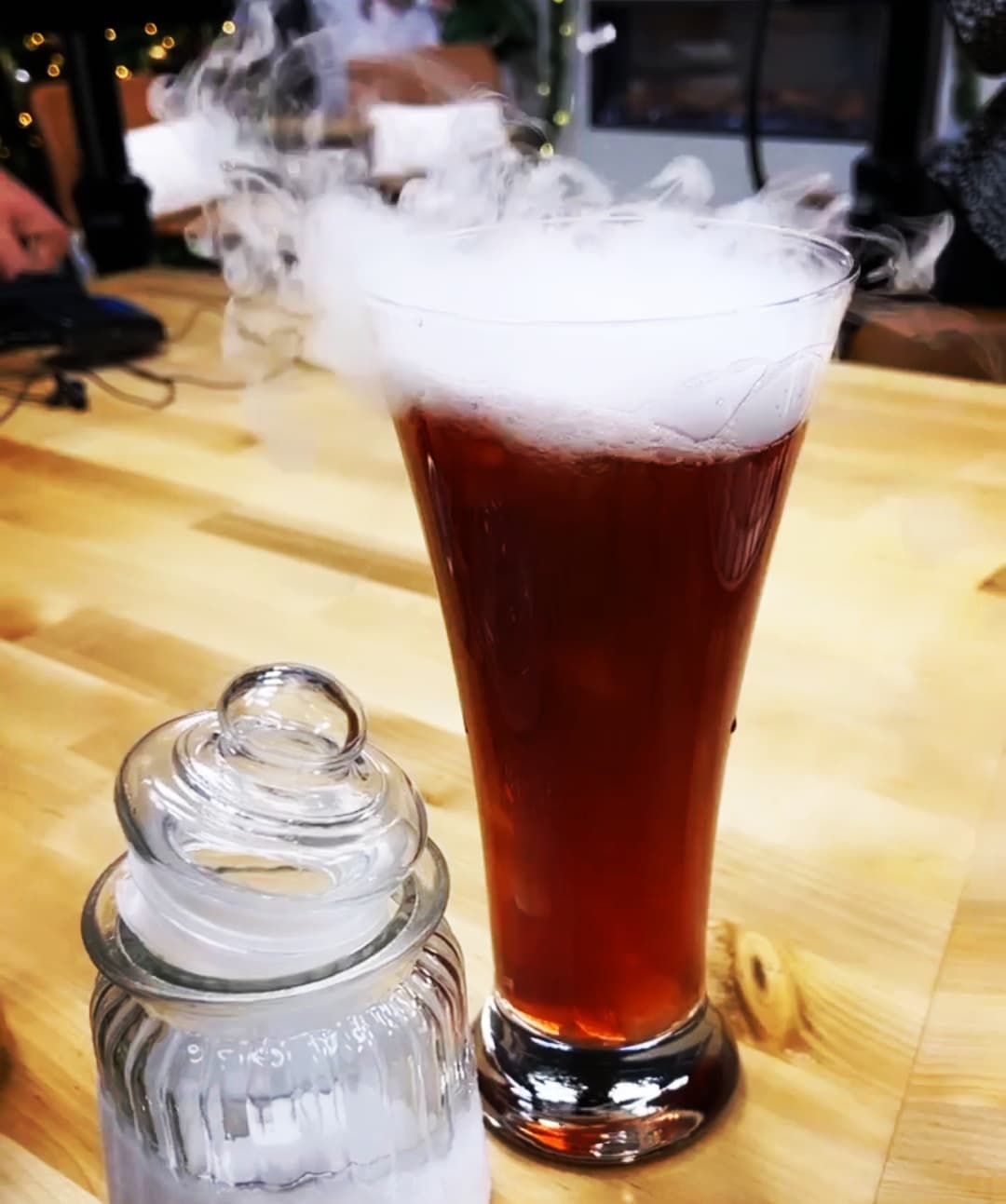 A tall glass of red liquid with steam coming off the top, meant to resemble â€œpolyjuice potionâ€ from the Harry Potter books. On the left is a small glass pot of what appears to be sugar. Photo from The Venue C-Uâ€™s Facebook page.
